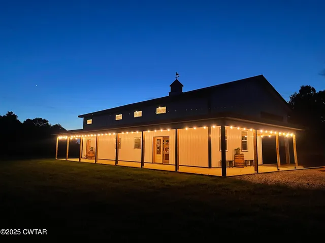 a front view of a house with a garden and trees