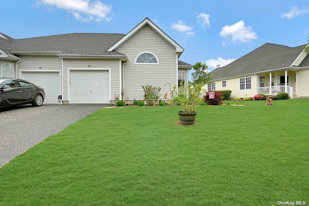 a front view of a house with a garden and trees