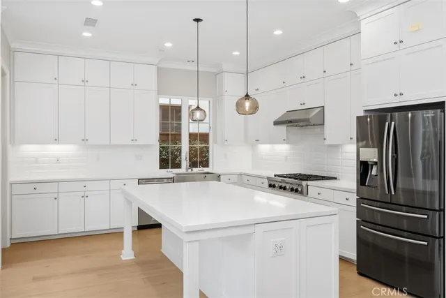 a kitchen with a refrigerator a sink and wooden floor