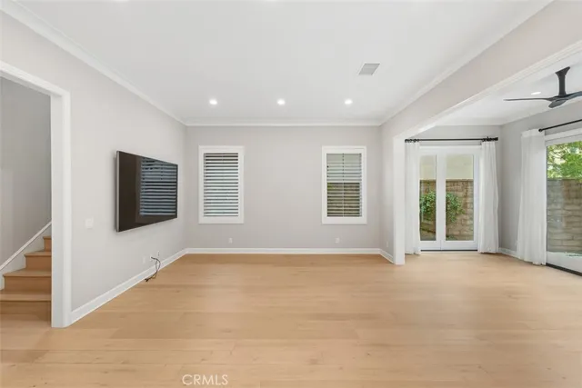 a view of an empty room with a window and a kitchen