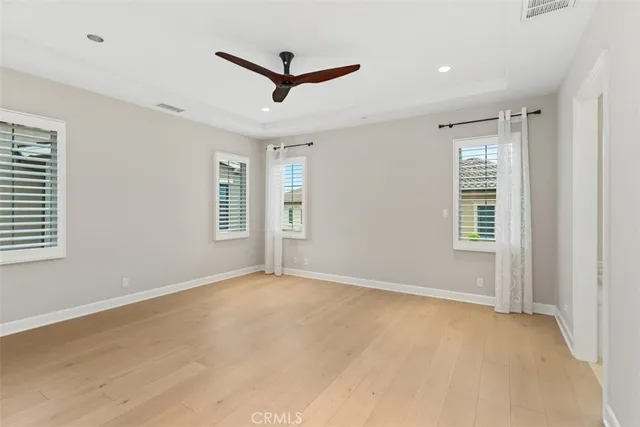 a view of a livingroom with a ceiling fan & windows