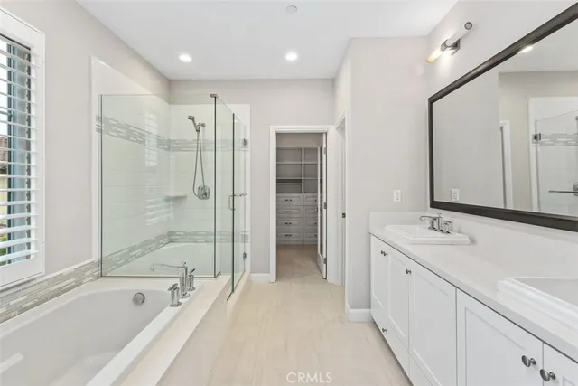 a spacious bathroom with a tub sink shower and mirror