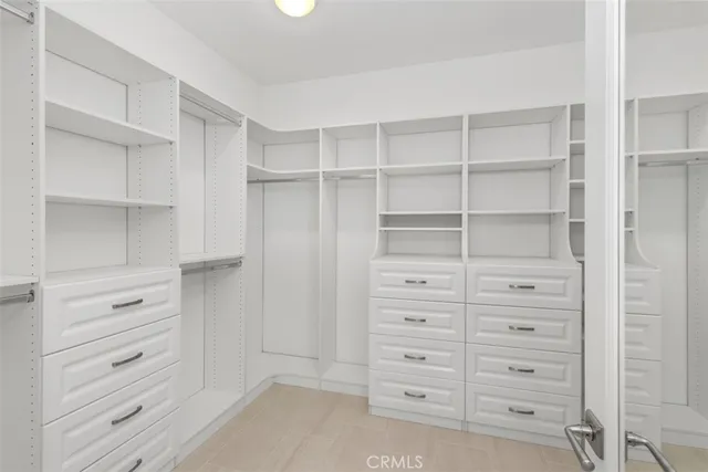 a view of walk in closet with clothes