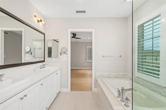 a spacious bathroom with a tub sink and mirror