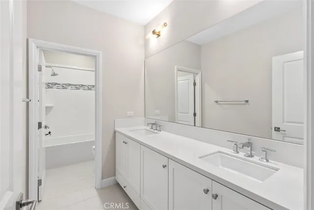 a bathroom with a tub a sink and mirror