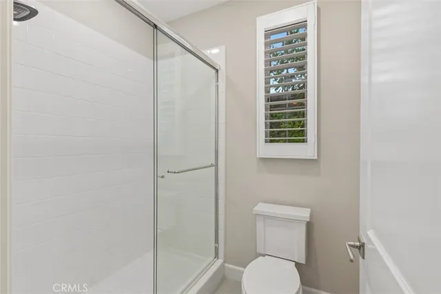 a bathroom with a toilet and a shower curtain