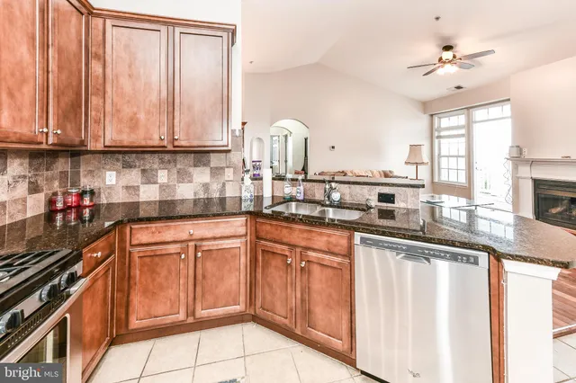 a kitchen with stainless steel appliances granite countertop a sink a stove and cabinets