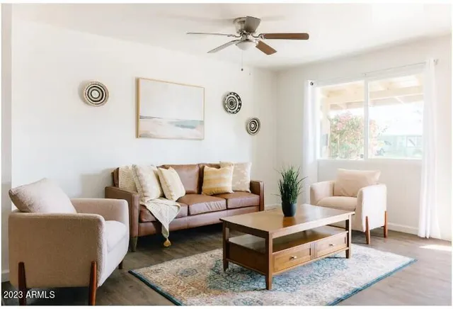 a living room with furniture a rug and a large window