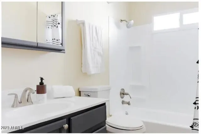 a bathroom with a sink vanity mirror and toilet