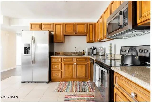 a kitchen with stainless steel appliances granite countertop a refrigerator stove and sink