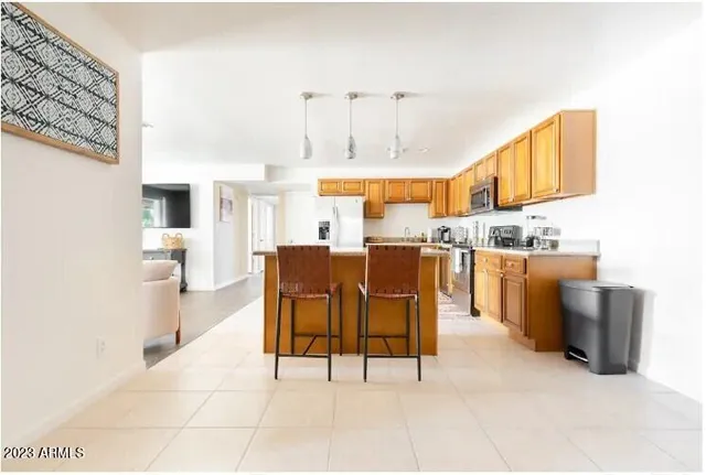 a room with stainless steel appliances kitchen island granite countertop furniture and a view of kitchen