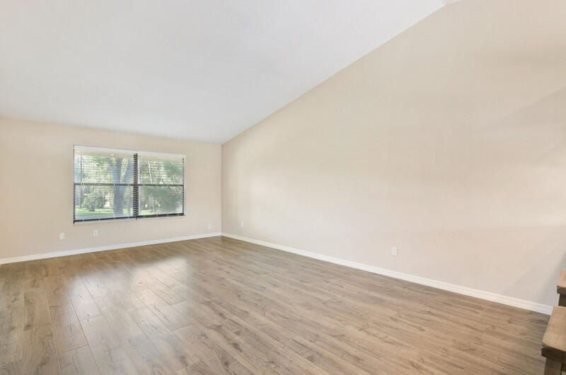 12949 Pennypacker Trail, Unit 4 Wellington, FL 33414 - Photo 8 of 18 a view of an empty room with wooden floor and a window