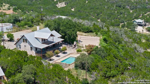 an aerial view of a house with swimming pool and garden