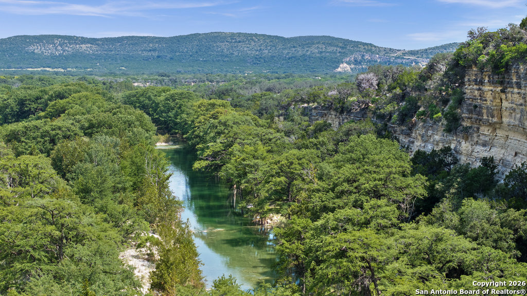 360 Bluebonnet Concan, TX 78838 - Photo 39 of 40 an aerial view of green landscape with trees houses and mountain view