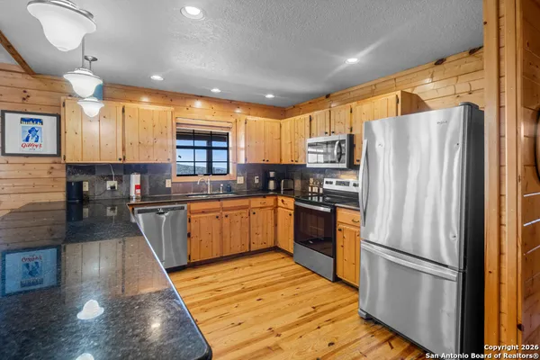 a kitchen with stainless steel appliances granite countertop a refrigerator sink and cabinets