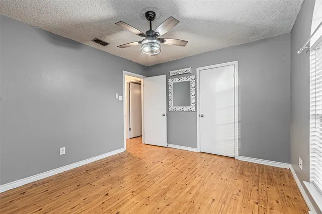 a view of a livingroom with a chandelier fan and wooden floor