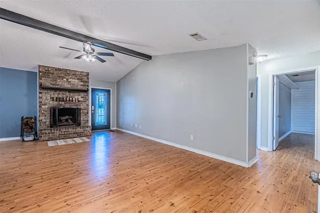 a view of a livingroom with wooden floor and a fireplace