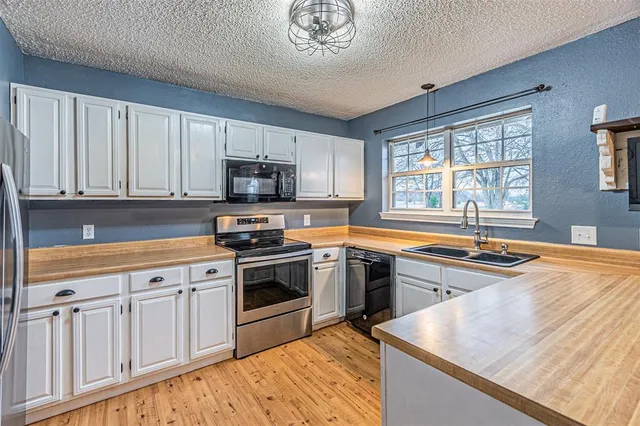 a kitchen with stainless steel appliances granite countertop a stove a sink and a microwave