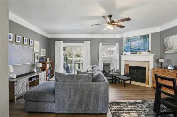 a living room with furniture a fireplace and a large window