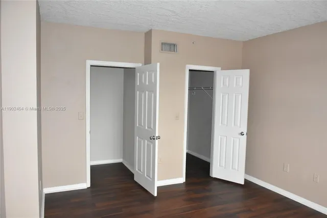 an empty room with wooden floor & closet