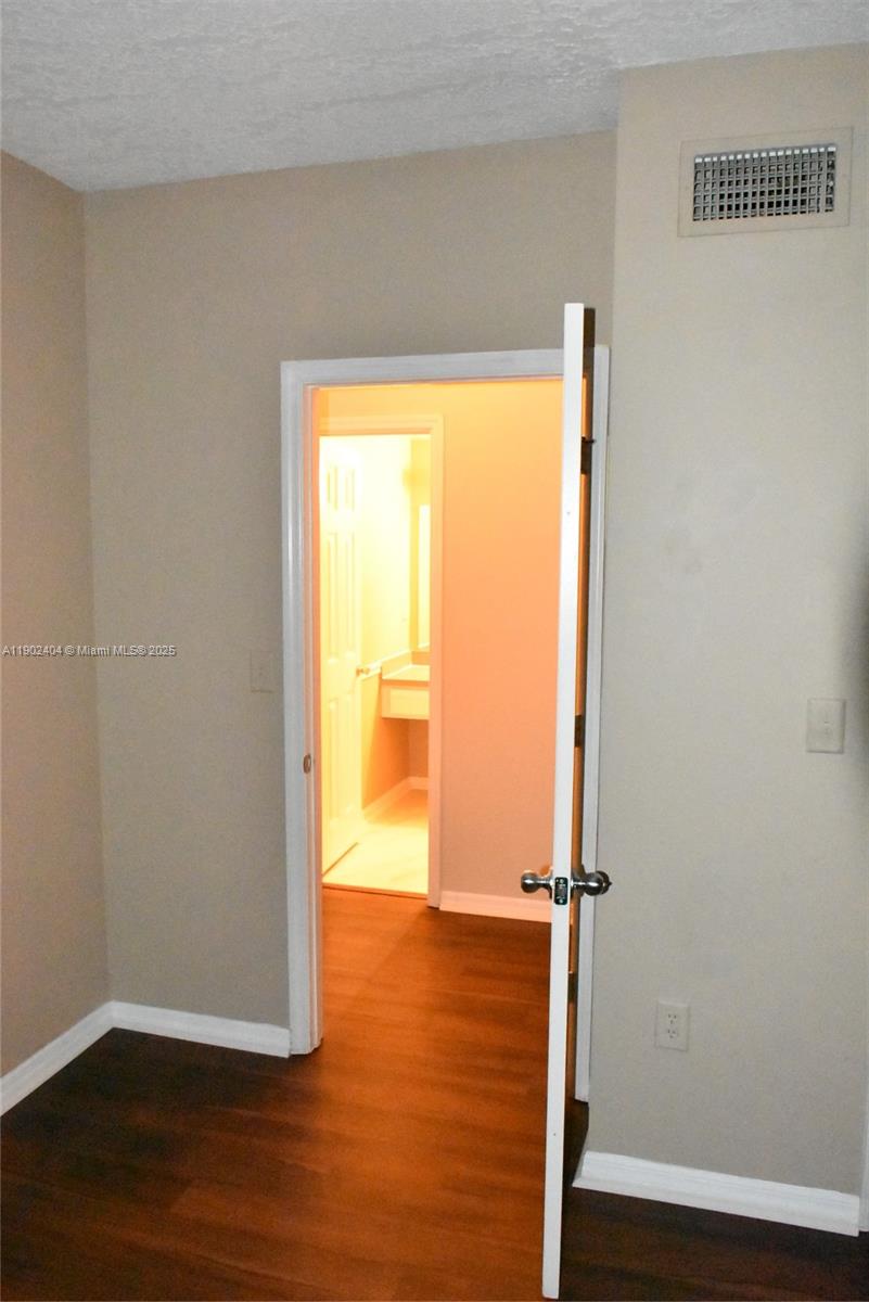 11701 Southwest 2nd Street, Unit 5305 Pembroke Pines, FL 33025 - Photo 23 of 27 a view of an empty room with wooden floor and a window