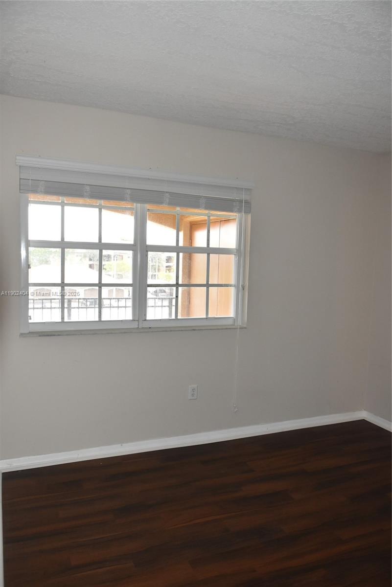 11701 Southwest 2nd Street, Unit 5305 Pembroke Pines, FL 33025 - Photo 7 of 27 a view of an empty room with wooden floor and a window