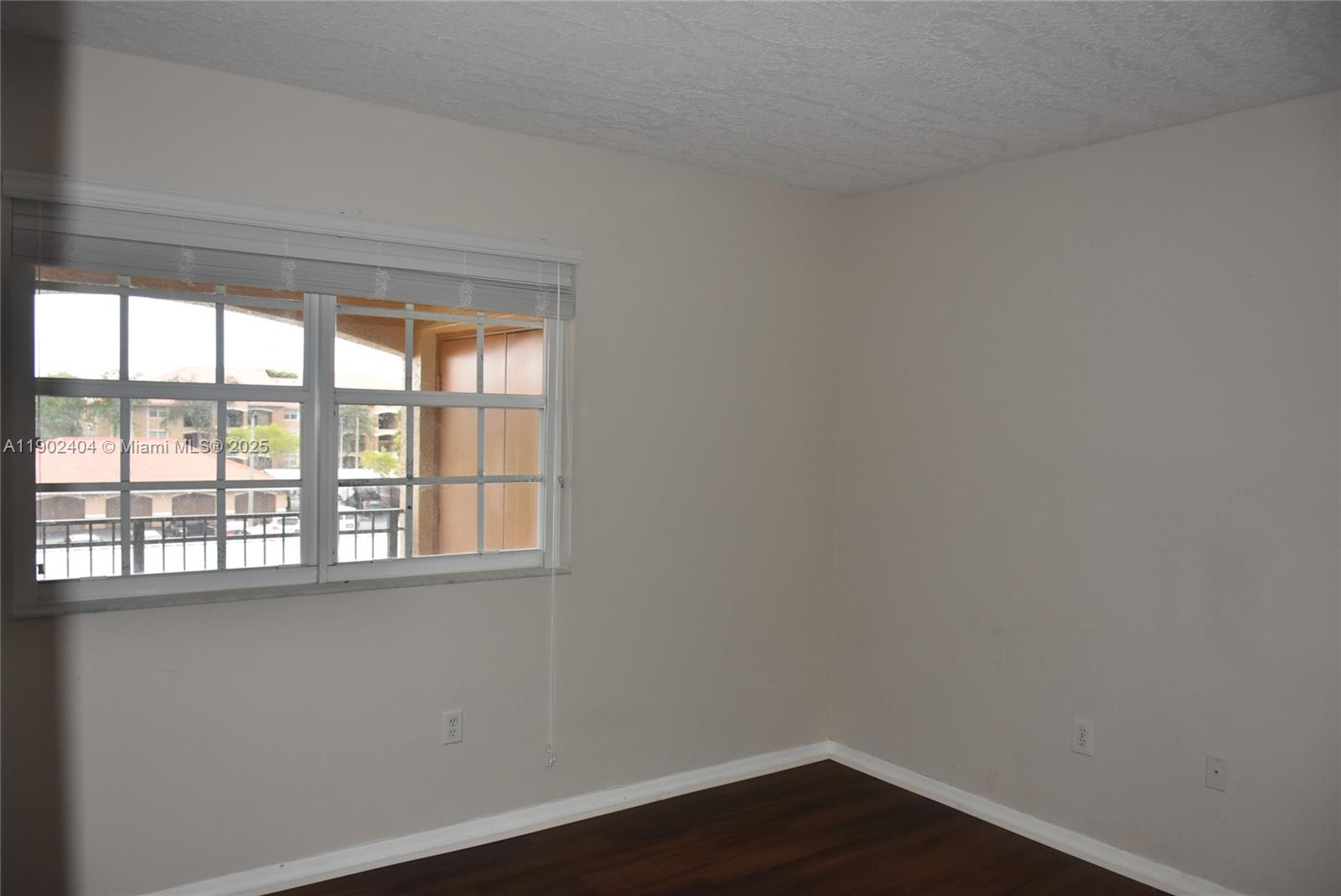 11701 Southwest 2nd Street, Unit 5305 Pembroke Pines, FL 33025 - Photo 8 of 27 a view of an empty room with wooden floor and a window