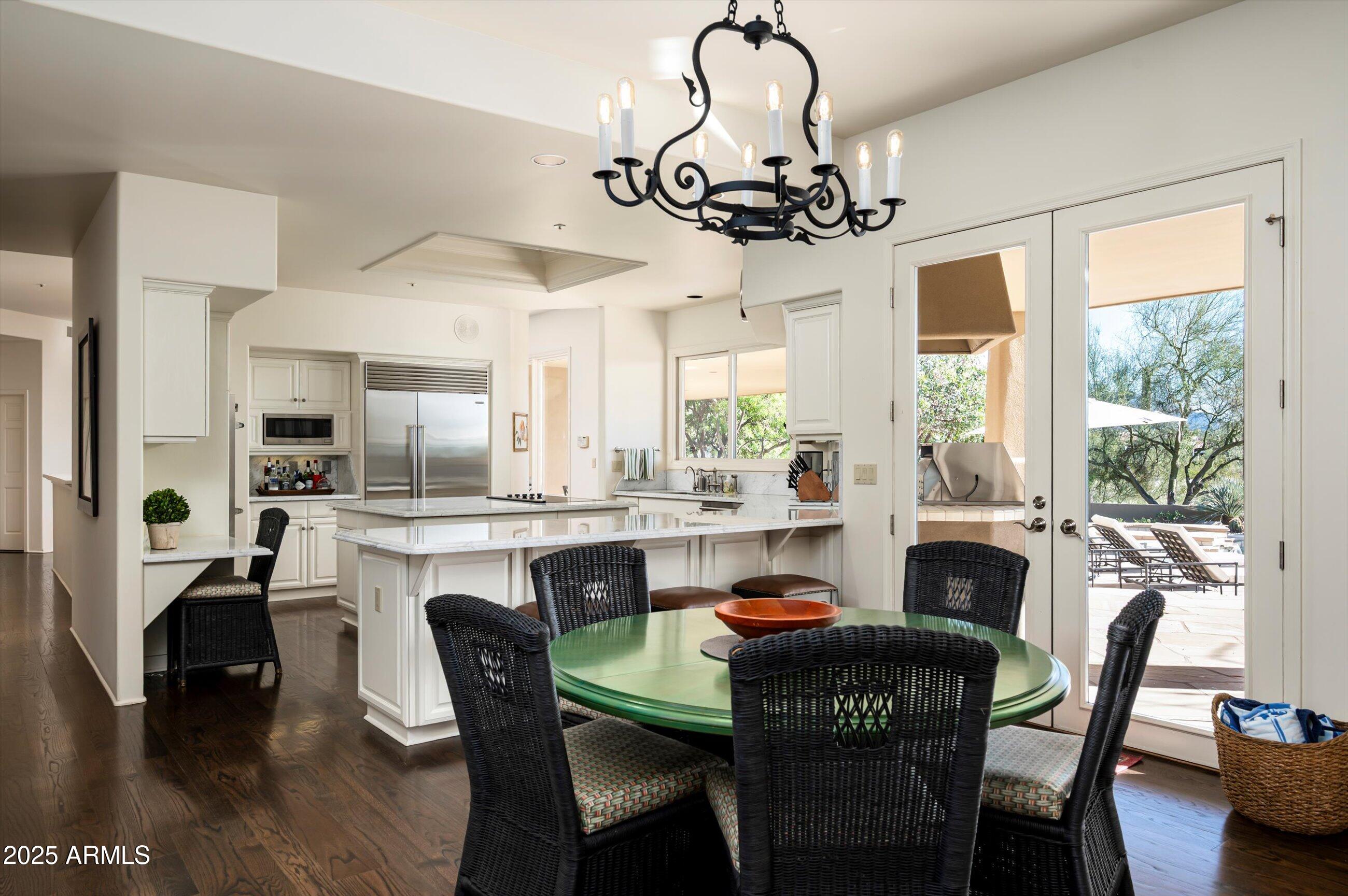 10040 East Happy Valley Road, Unit 274 Scottsdale, AZ 85255 - Photo 17 of 73 a dining room with furniture a chandelier and wooden floor