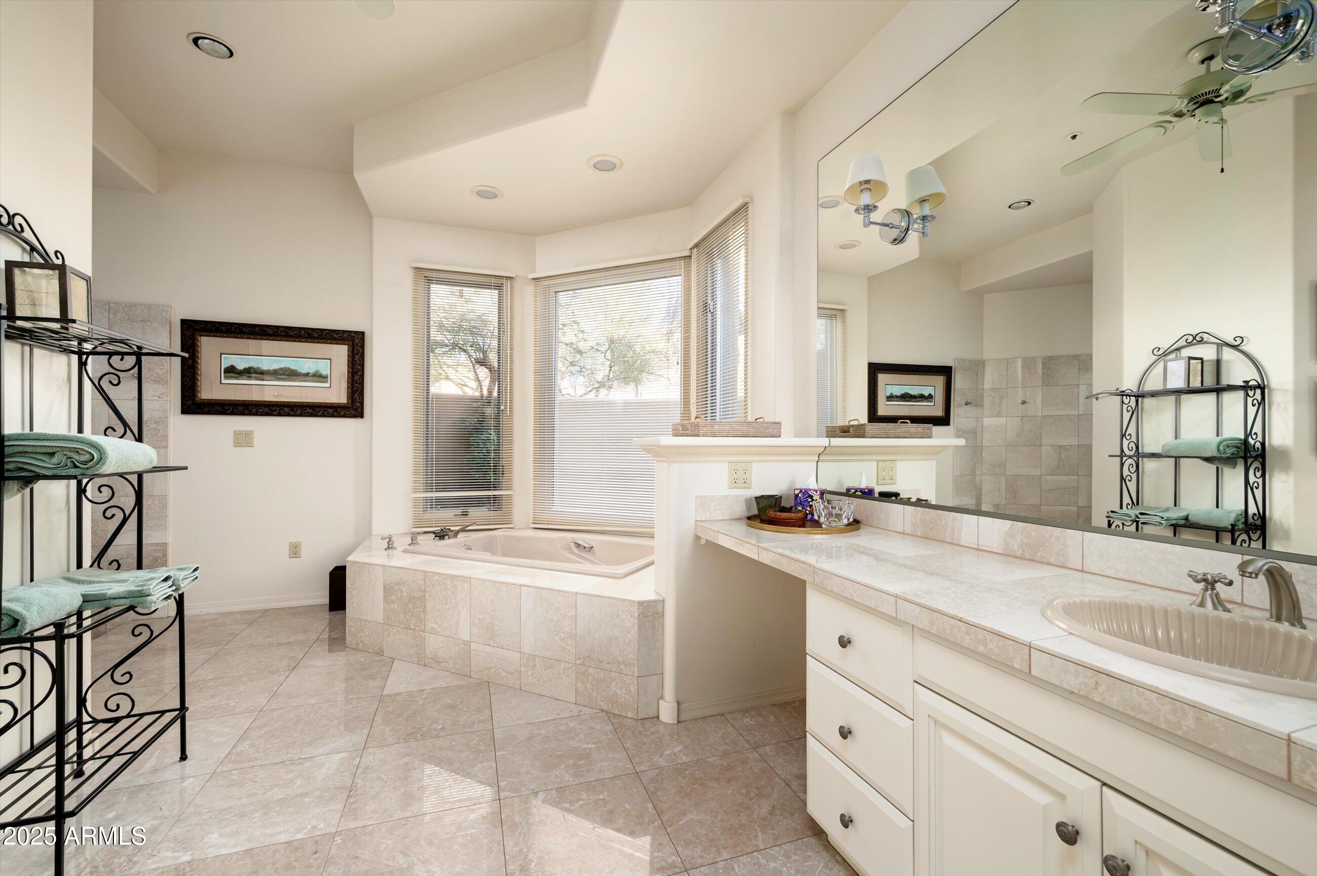 10040 East Happy Valley Road, Unit 274 Scottsdale, AZ 85255 - Photo 30 of 73 a spacious bathroom with a granite countertop sink a large mirror and a bathtub