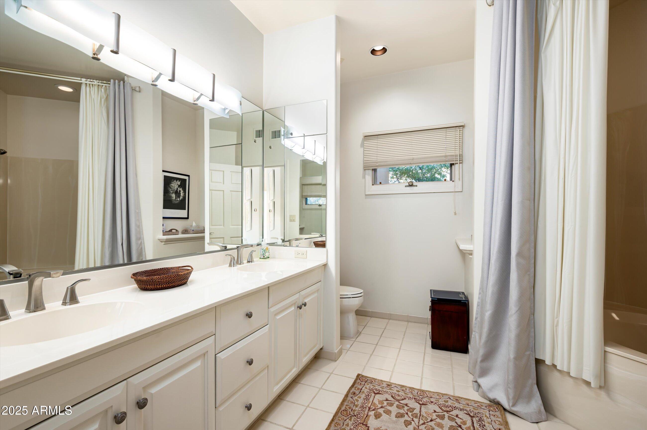 10040 East Happy Valley Road, Unit 274 Scottsdale, AZ 85255 - Photo 36 of 73 a bathroom with a double vanity sink a mirror and a shower