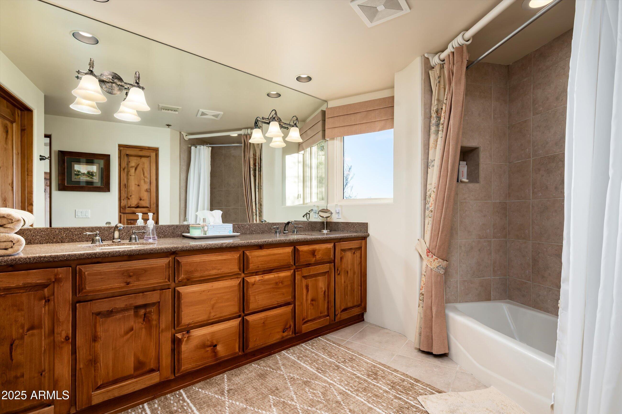 10040 East Happy Valley Road, Unit 274 Scottsdale, AZ 85255 - Photo 41 of 73 a bathroom with a tub a double vanity sink and mirror