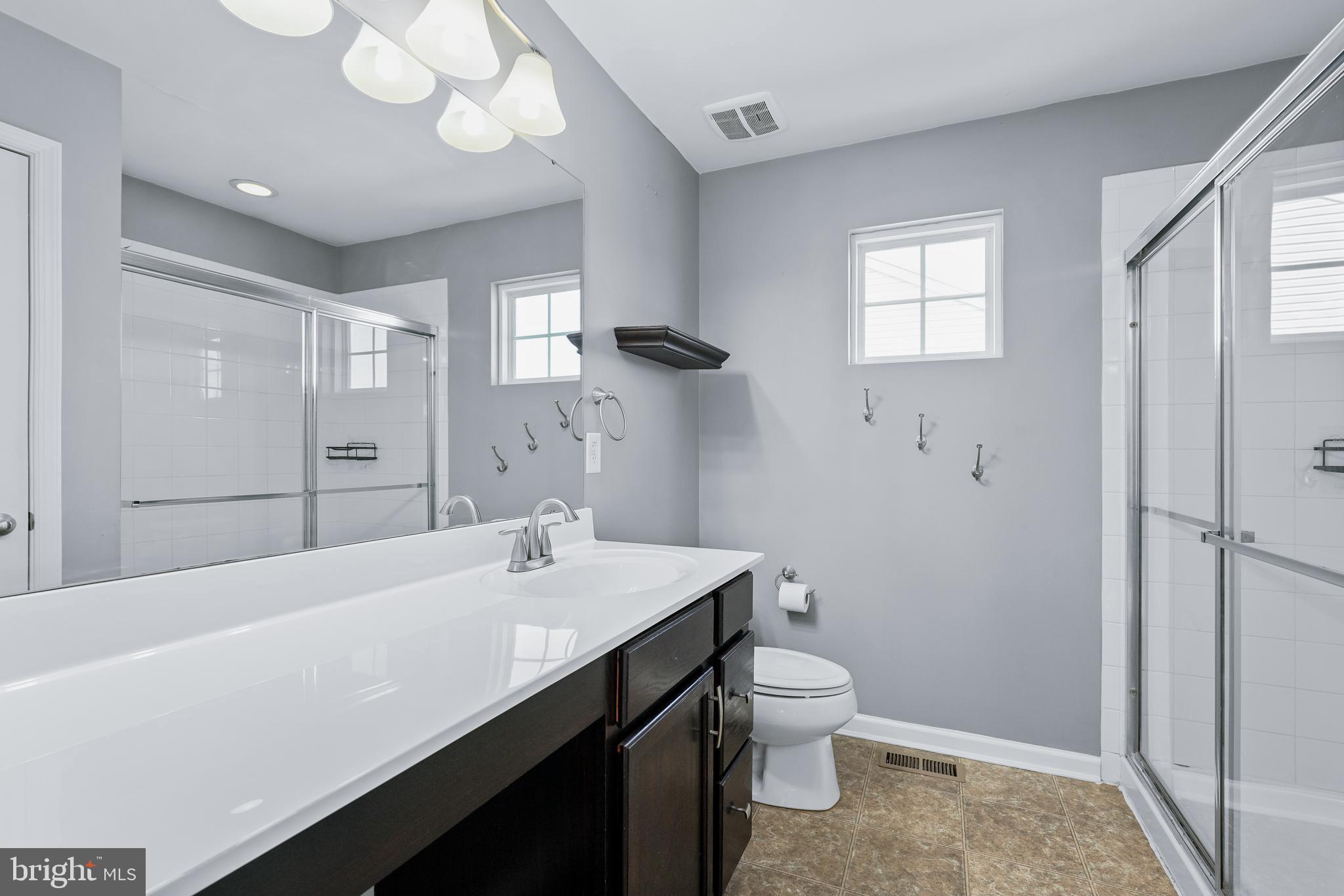 144 Abbigail Crossing Townsend, DE 19734 - Photo 23 of 33 a bathroom with a sink a toilet and a large mirror