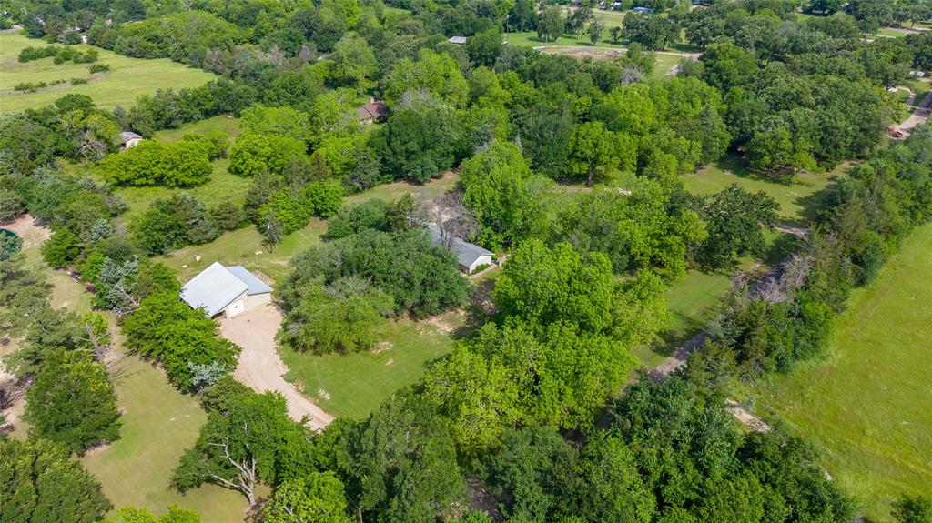 96 Southeast 12th Street Cooper, TX 75432 - Photo 30 of 32 a view of a house with a lush green forest