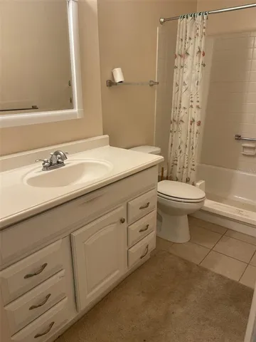 a bathroom with a granite countertop toilet a sink and a mirror
