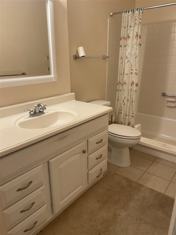 3117 Mission Grove Drive Palm Harbor, FL 34684 - Photo 16 of 25 a bathroom with a granite countertop toilet a sink and a mirror
