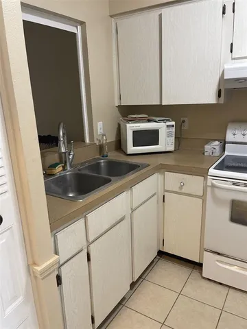 a kitchen with white cabinets sink and white appliances