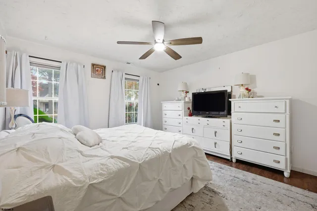 a bedroom with a bed a flat screen tv and a window
