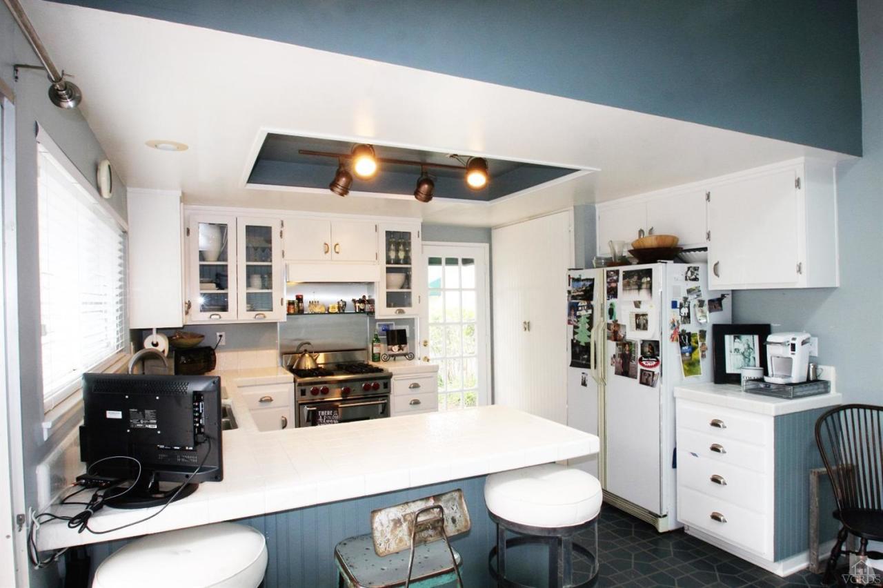 1800 Capstan Drive Oxnard, CA 93035 - Photo 5 of 15 a kitchen with stainless steel appliances a stove a refrigerator a white table and chairs