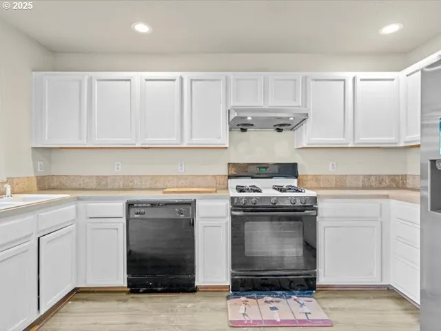 a kitchen with white cabinets and appliances