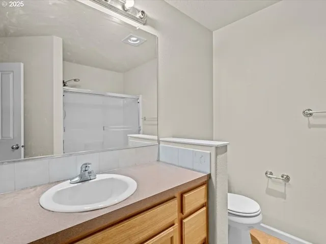 a bathroom with a sink a toilet and a mirror