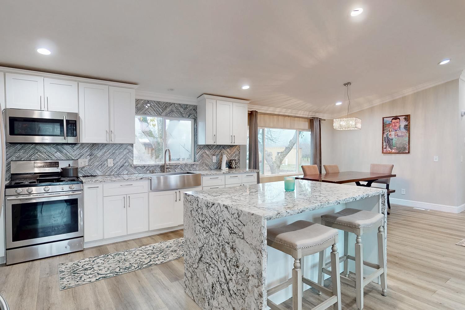 3453 La Porte Road Marysville, CA 95901 - Photo 16 of 81 a kitchen with stainless steel appliances granite countertop a stove a sink a microwave a dining table and chairs