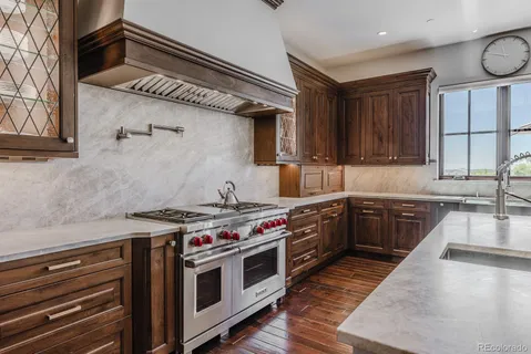 a kitchen with sink a stove and cabinets