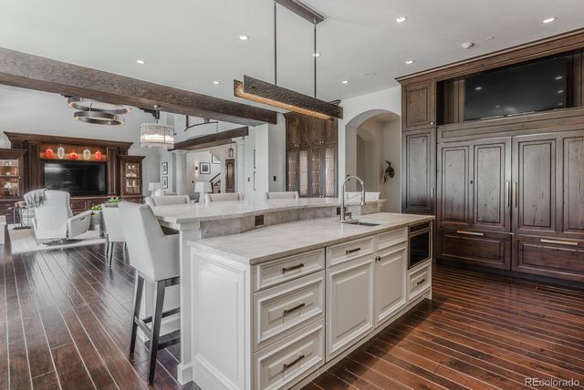 a kitchen with stainless steel appliances granite countertop a sink a stove and a wooden cabinets