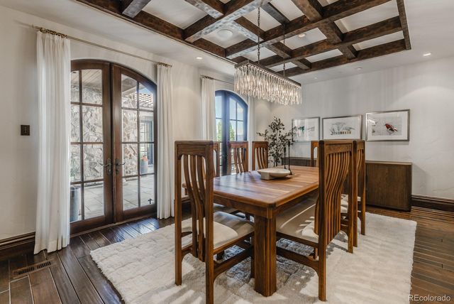a dining room with furniture a chandelier and wooden floor