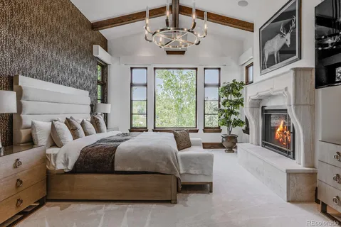 a bed room with a fireplace and a television