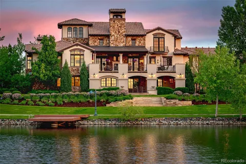 a front view of a house with a garden and a lake view