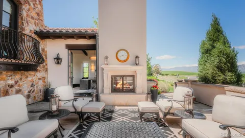 a living room with furniture a fireplace and a floor to ceiling window