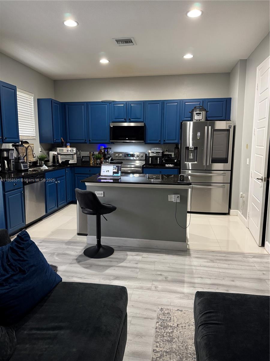 679 Northeast 193rd Street Miami, FL 33179 - Photo 2 of 4 a kitchen with stainless steel appliances granite countertop a stove a sink dishwasher a refrigerator and a oven with wooden floor