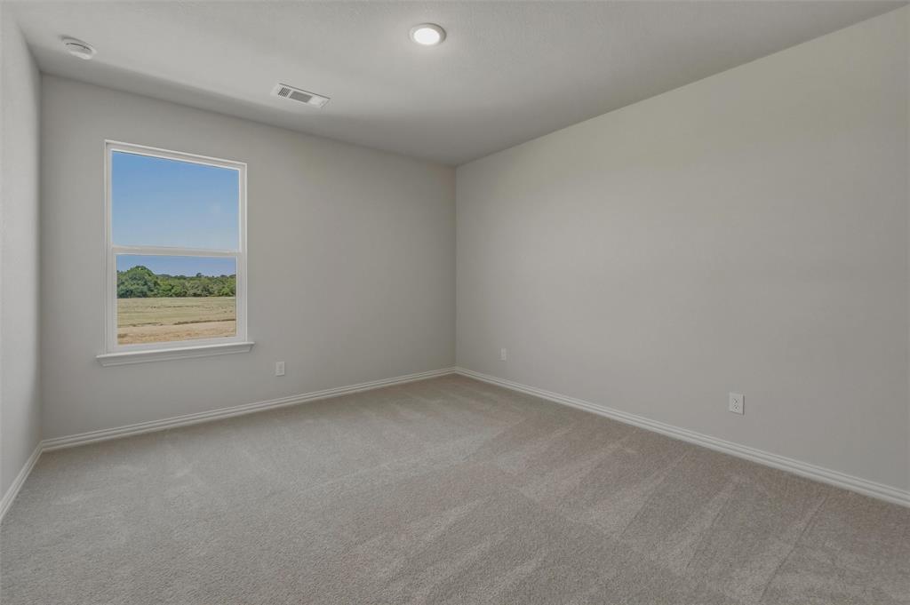 1337 Frio Drive Springtown, TX 76082 - Photo 21 of 40 Spacious room featuring neutral carpeting, light-toned walls, and a large window with natural light