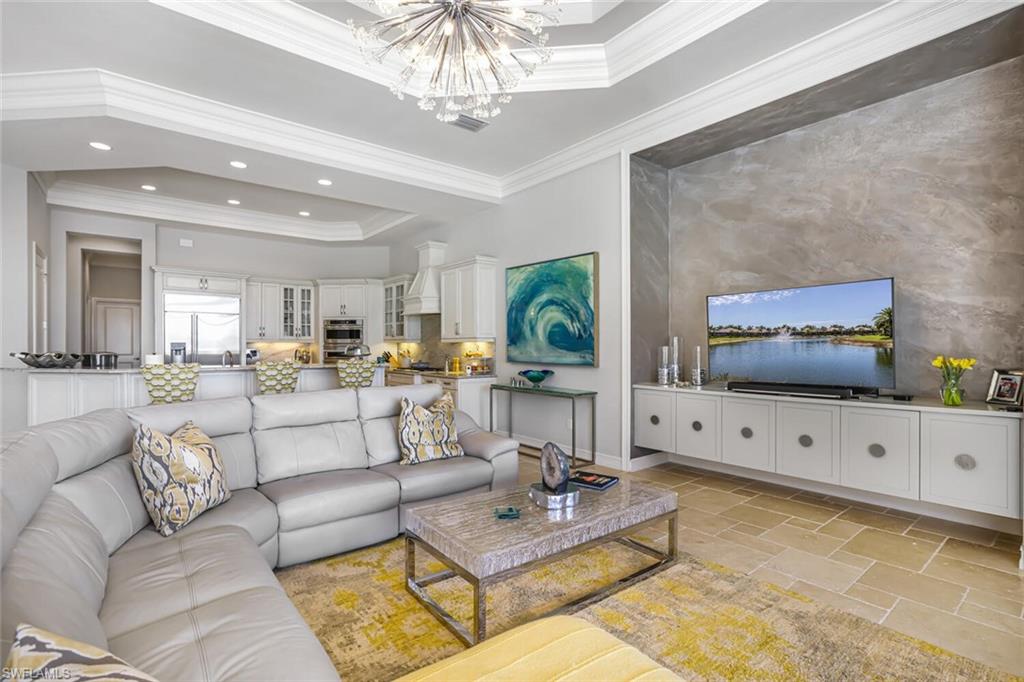 6624 Barbera Lane Naples, FL 34113 - Photo 14 of 50 a living room with furniture a chandelier and a flat screen tv